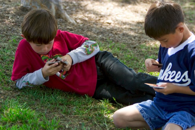 The boys play cards while they wait for their sisters' game to start