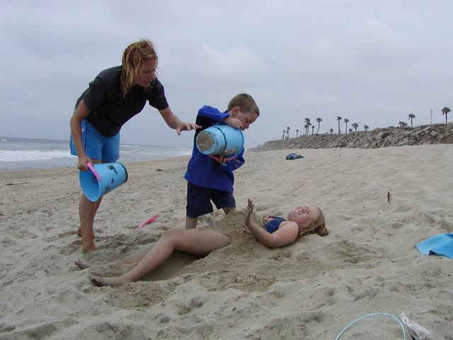 Timothy and Steffie pile sand on Sara