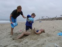 Timothy and Steffie pile sand on Sara