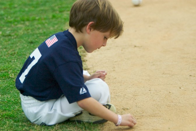 Max plays in the sand behind the backstop