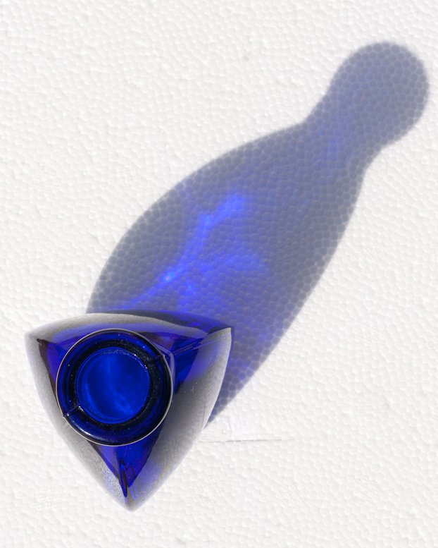 Triangular blue glass bottle