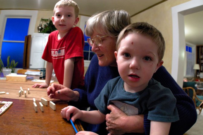 Logan and Aaron help Maureen play dominos