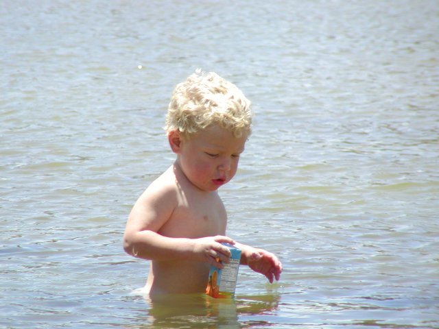 Timothy carries his orange juice back across the lagoon